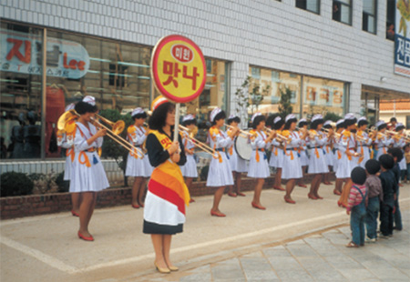 1984년 3月 26일 맛나 판촉 및 기업 이미지 제고를 위해 식품업계 최초로 창설한 ‘맛나 고적대’ 이미지